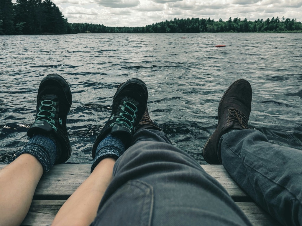 Two pairs of feet on the dock.