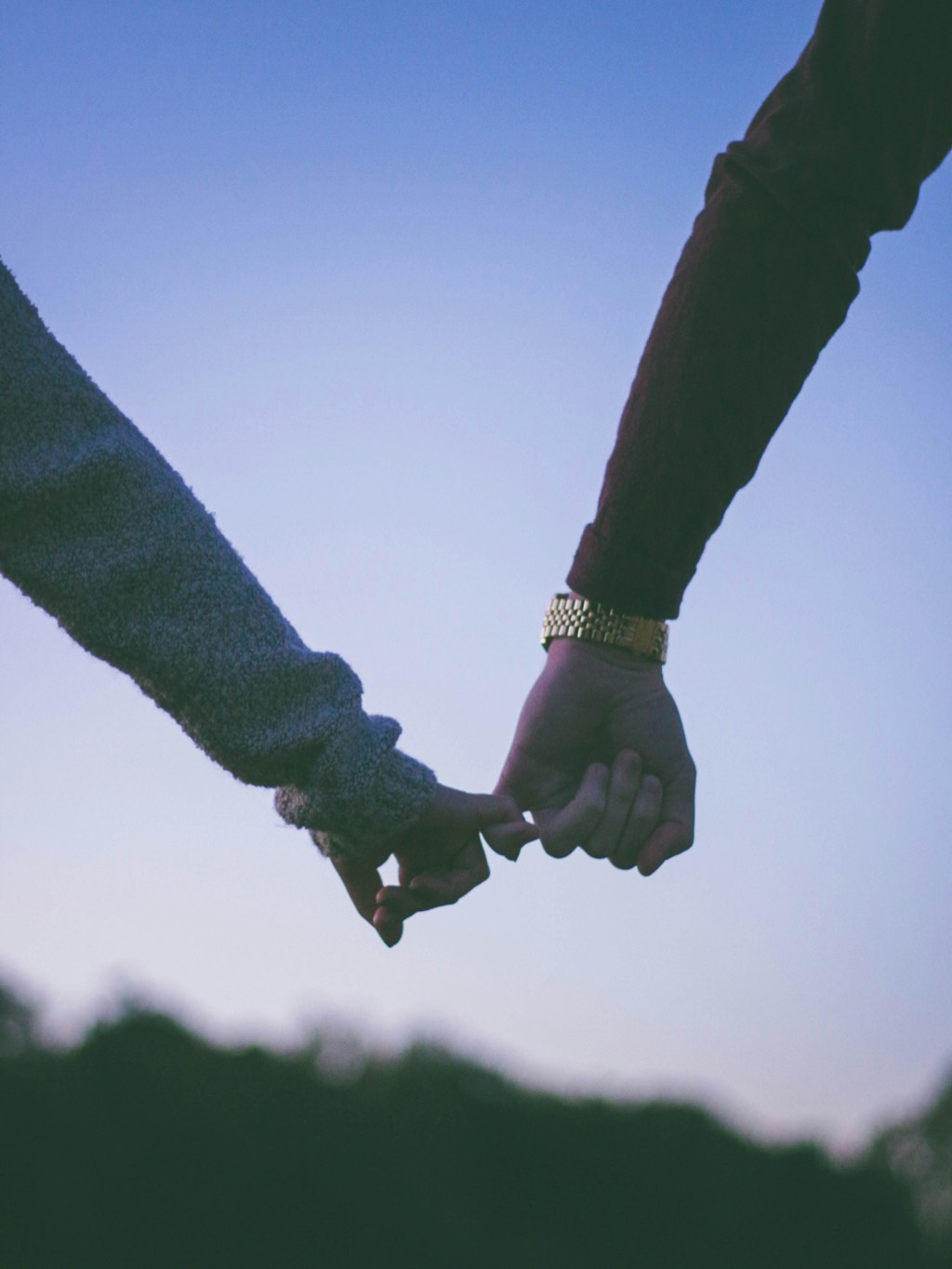 Two hands holding, mid-walk.