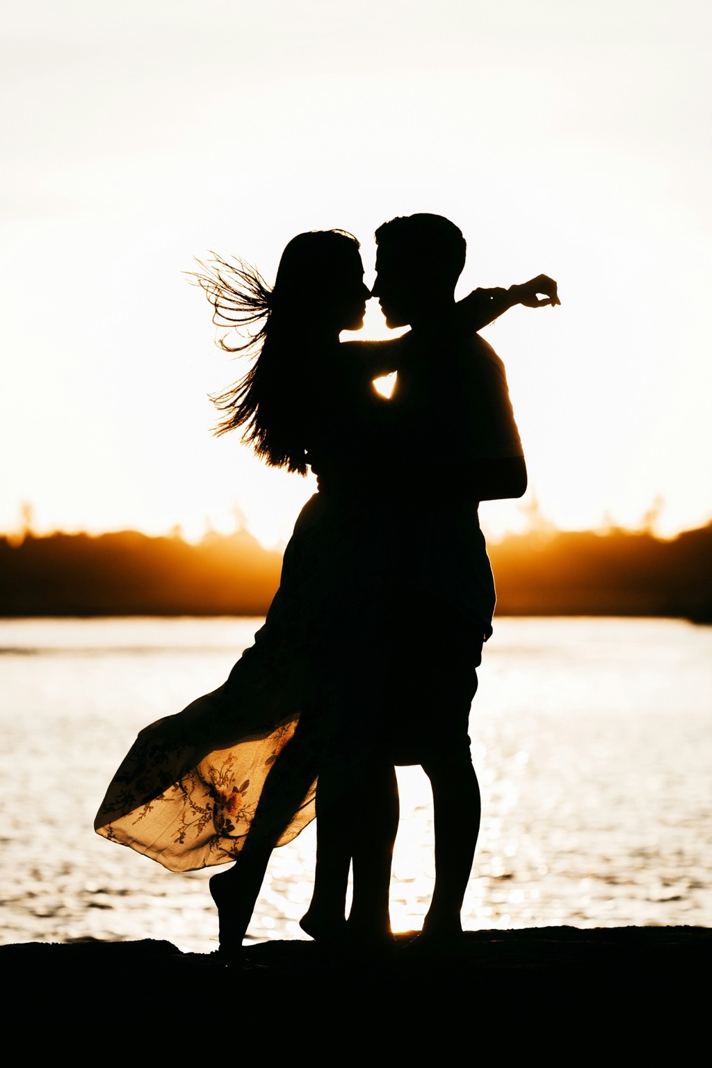 A couple embracing in silhouette.
