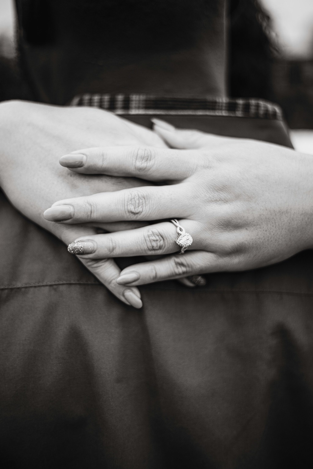 Hands layered together, a ring visible.